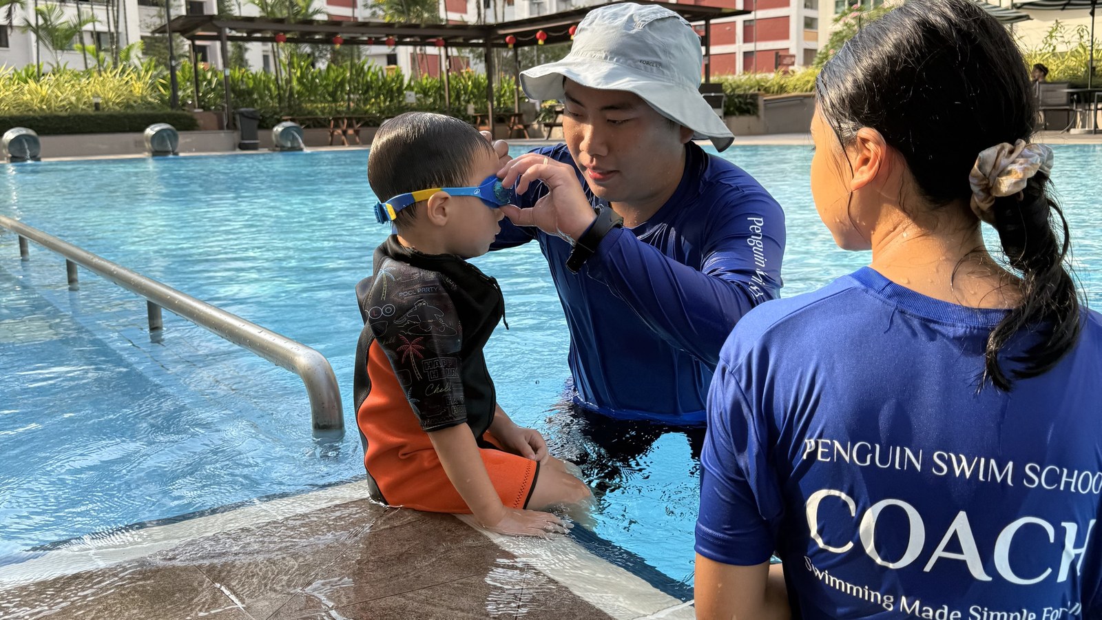 Penguin Swim School coach fitting goggles before a lesson